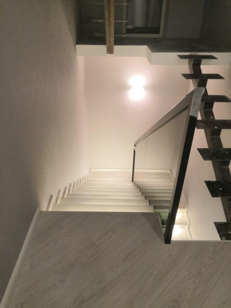 Лестница со стеклянными перилами и подсветкой ступеней