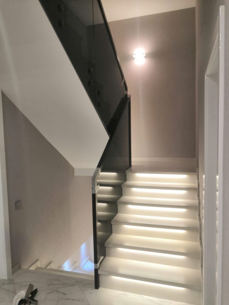 Лестница со стеклянными перилами и подсветкой ступеней