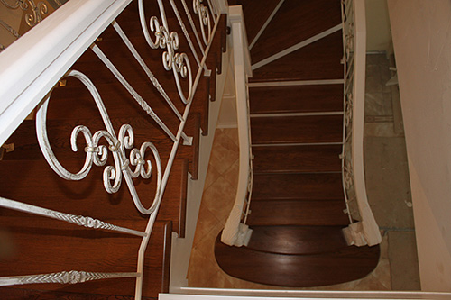 152. Деревянная двухмаршевая лестница с забежными ступенями и кованым ограждением